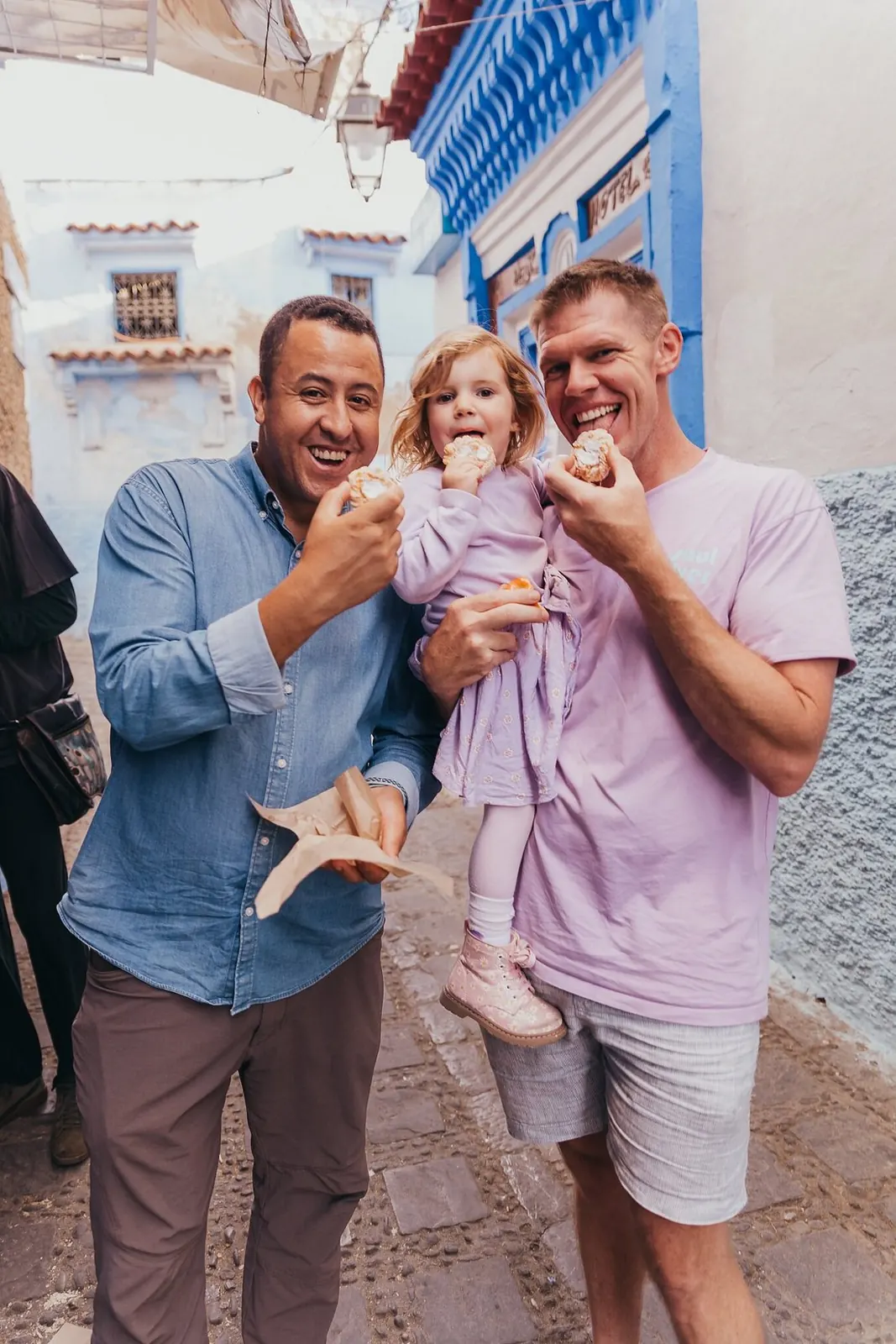 A local guide leading a family through a blue-painted alley in Chefchaouen, relaxed and unhurried