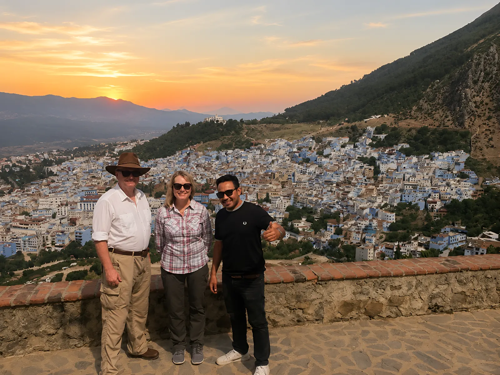 Travellers watching the sunset from a hilltop viewpoint above the Chefchaouen medina