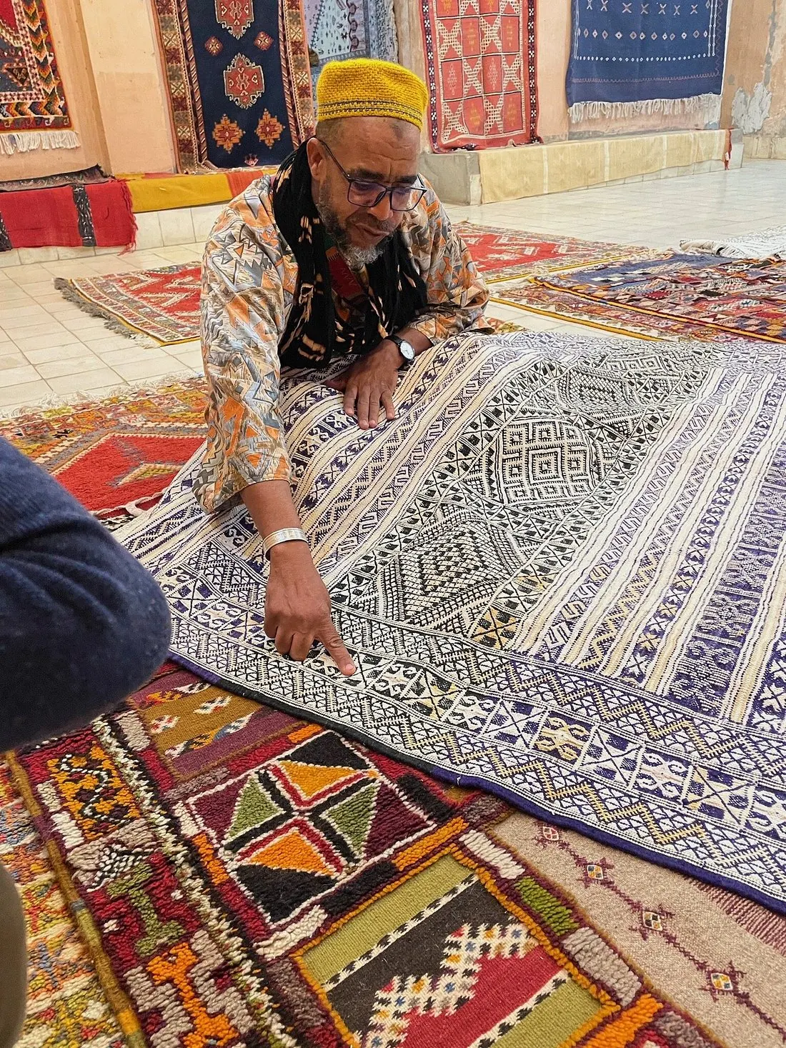 Berber craftsman displaying intricate carpet patterns