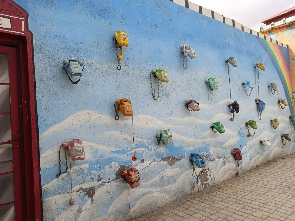 Colourful vintage telephones mounted on a blue wall at Atlas Studios