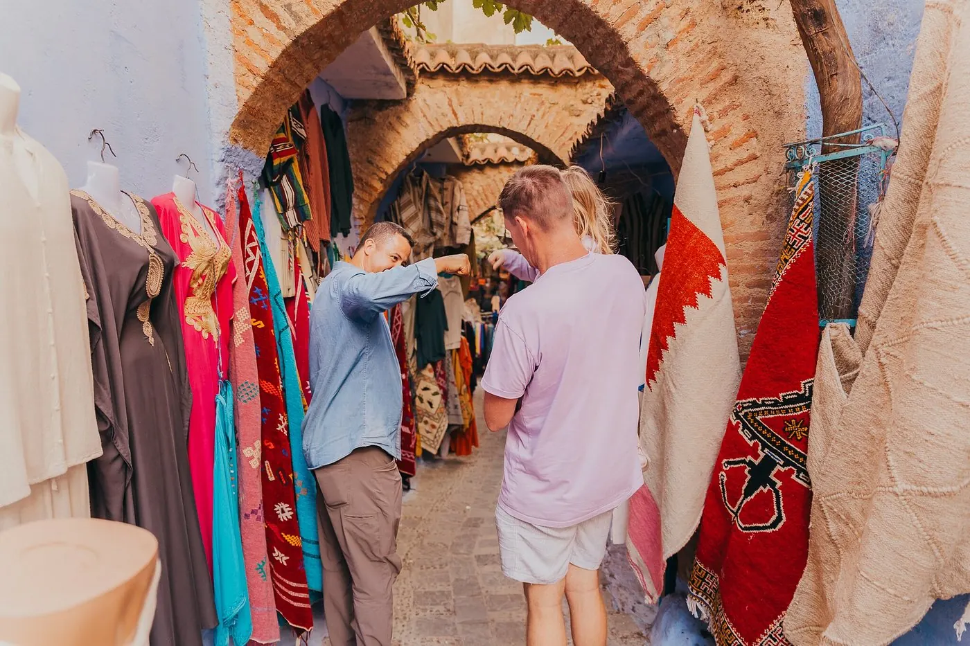 Travellers browsing a colourful stall in the Marrakech souk