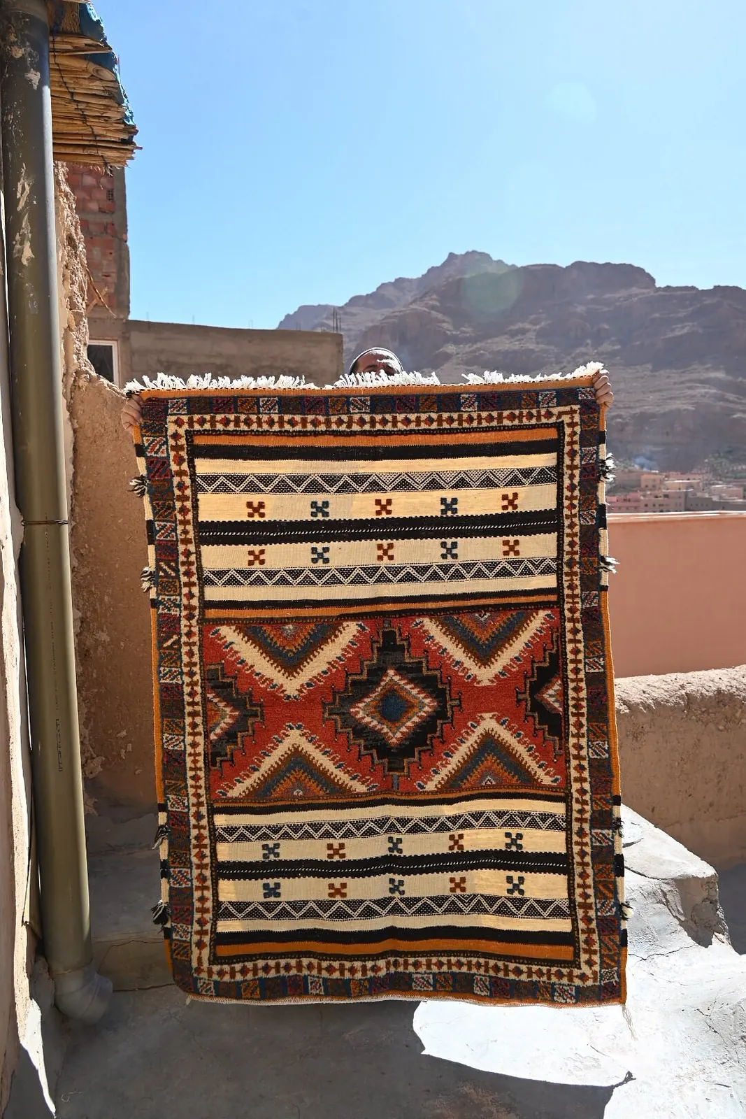 An artisan working in a medina souk, surrounded by handwoven rugs and traditional craft