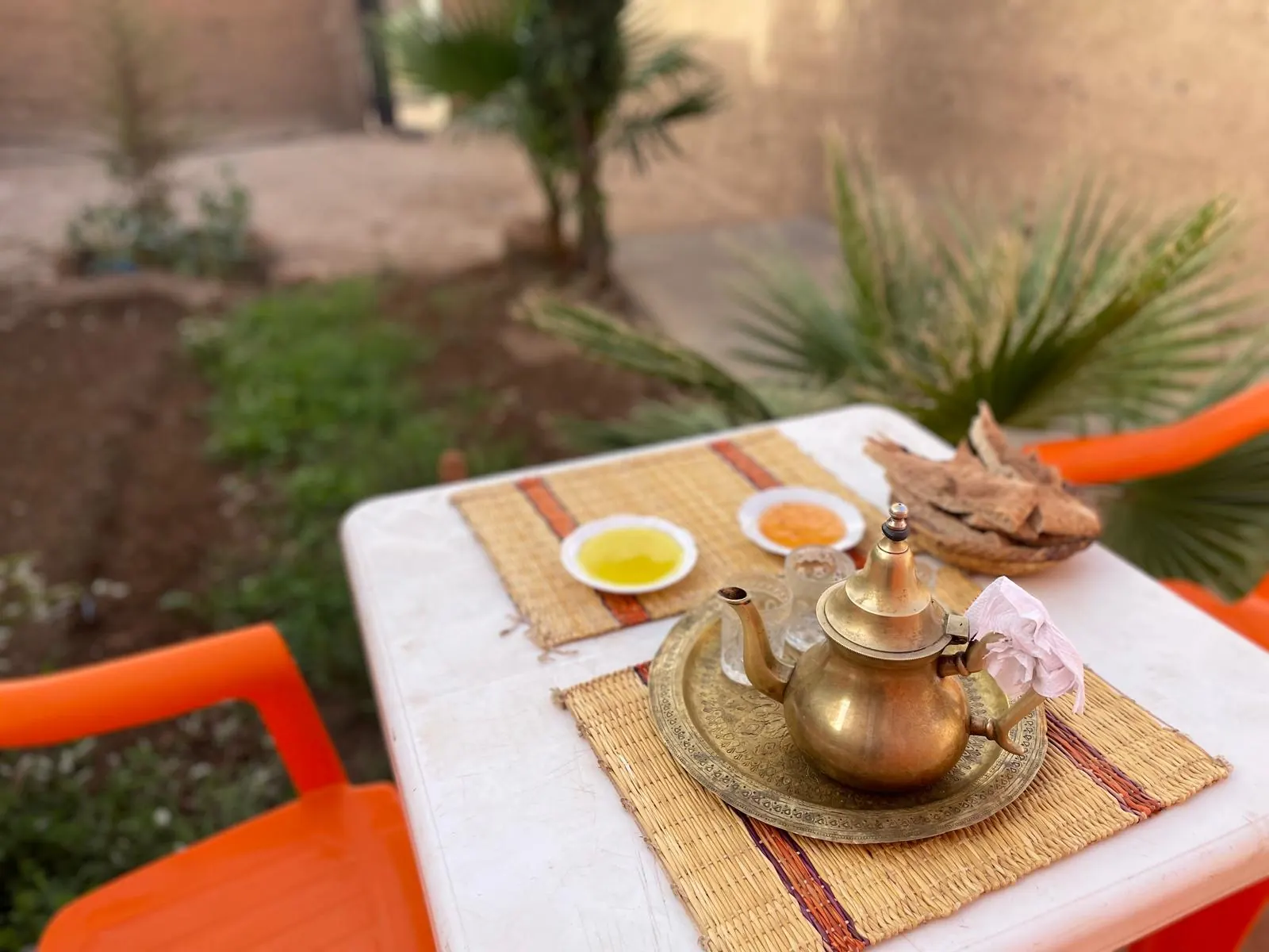 Moroccan mint tea served in small glasses on a garden table, steam rising from the surface