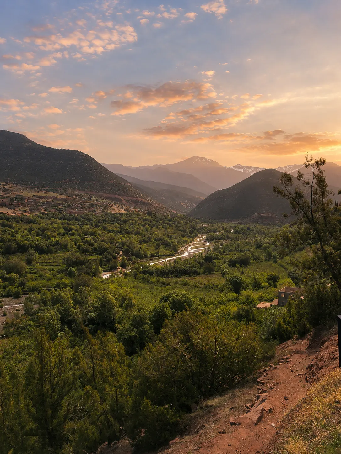 The Ourika river winding through a lush green valley at sunset
